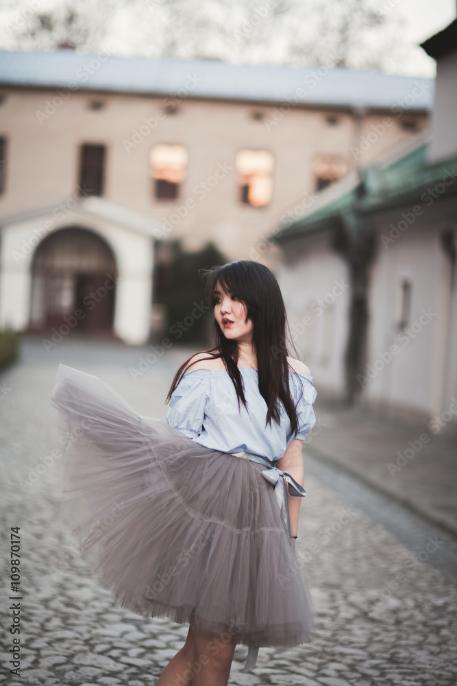 Obraz premium Young Asians girl with modern dress posing in an old Krakow