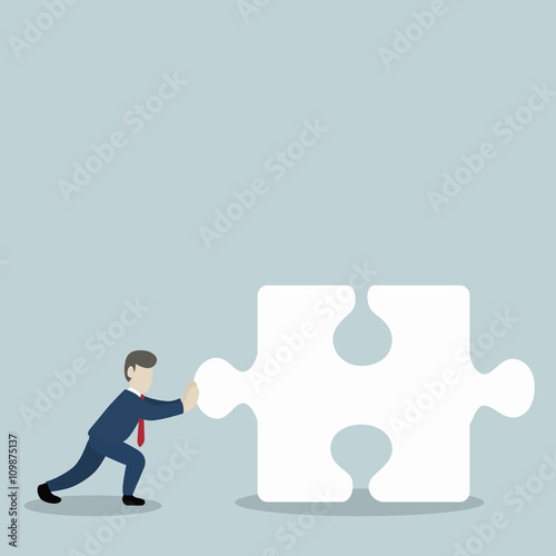 Businessmen pushing jigsaw piece