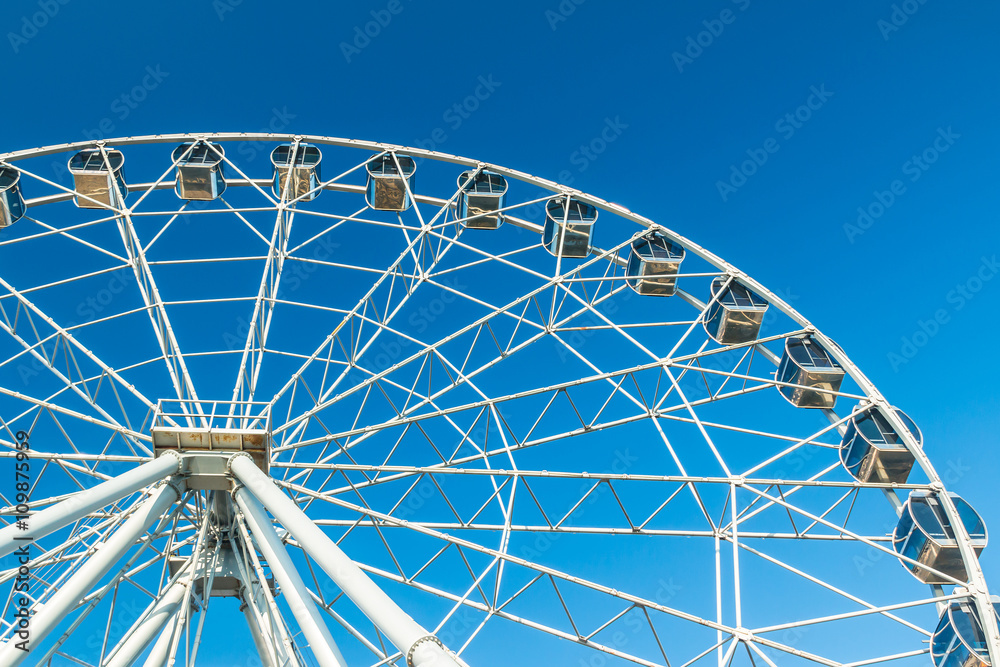 Ferris wheel on the background of clear blue sky on a sunny day. Ferris wheel on the background of clear blue sky on a sunny day.