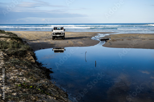 Tableau sur toile Land Rover Defender preparing to cross a lake formed on the sand in Fraser Islan