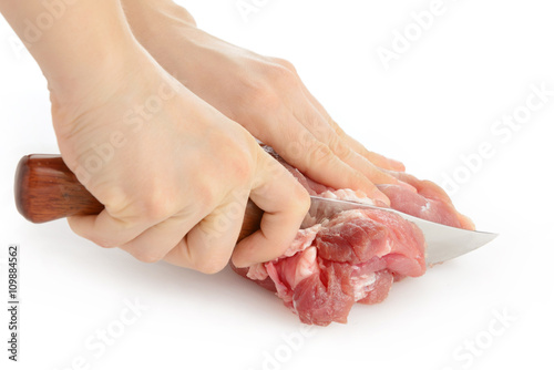 Hands of cook cutting meat