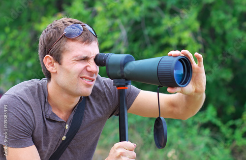 Man who is watching in spotting scope.  photo