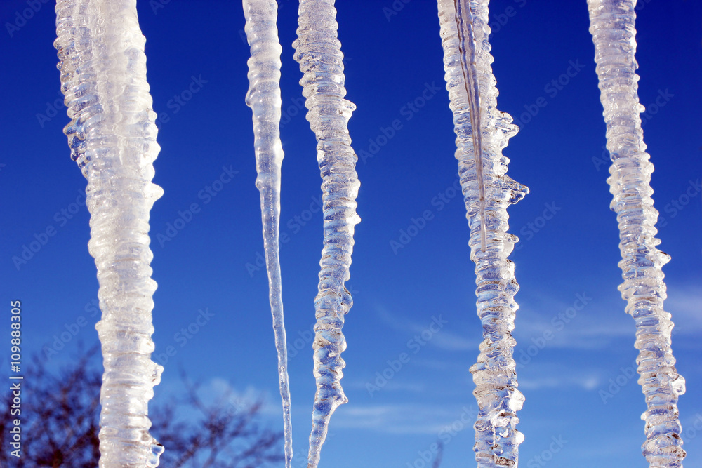 Icicles on the blue sky background Icicles on the blue sky background