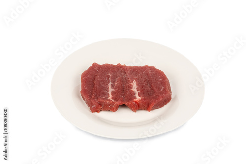 Raw meat laying on the plate.