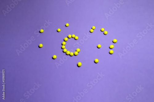 Ascorbic acid in the yellow pills on a colored background