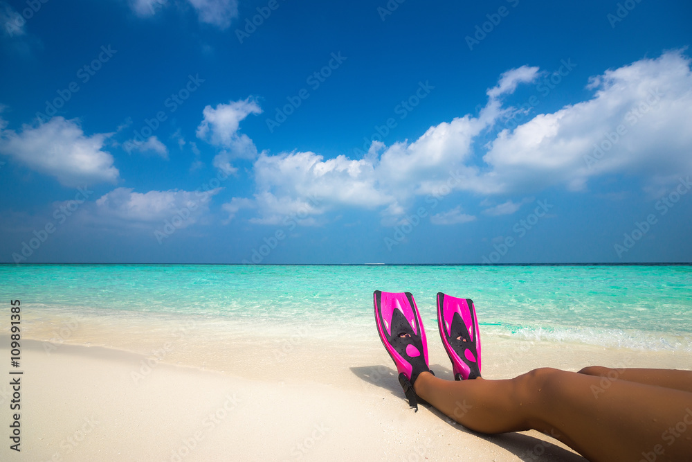 Woman relaxing on summer beach vacation holidays lying in sand.