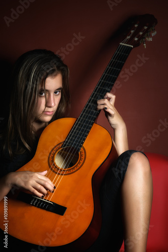 Rebellious teenage girl holding an acoustic guitar
