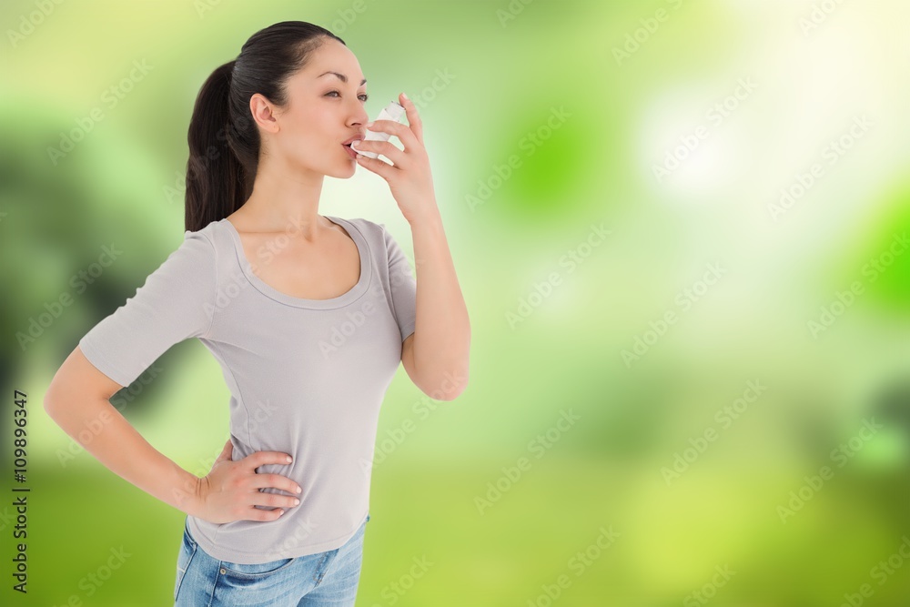 Composite image of asthmatic pretty brunette using inhaler Composite image of asthmatic pretty brunette using inhaler