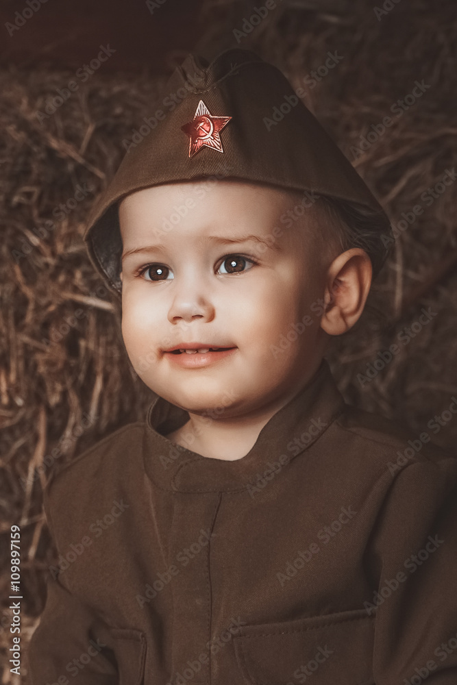Retro! One year smiling baby dressed in Second World War russian uniform. Hay background Retro! One year smiling baby dressed in Second World War russian uniform. Hay background