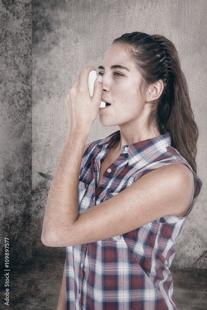 Composite image of woman having asthma using the asthma inhaler Composite image of woman having asthma using the asthma inhaler