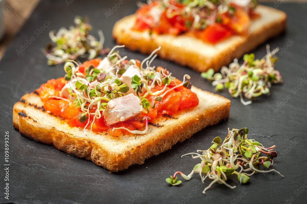 Grilled toasted bread with roasted tomatoes, feta cheese and radish sprouts. Grilled toasted bread with roasted tomatoes, feta cheese and radish sprouts.