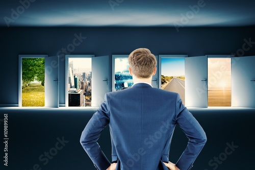 Composite image of rear view of businessman standing with hands  photo