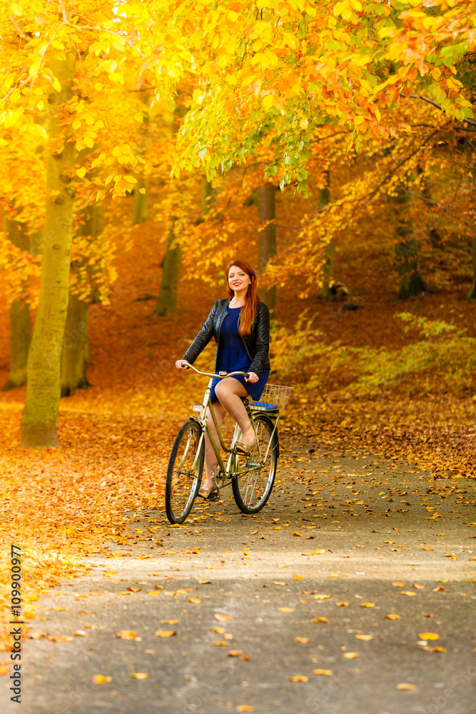 Beauty girl relaxing in autumn park with bicycle, outdoor