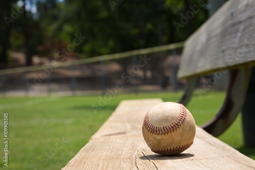 Baseball on a bench in a little league field