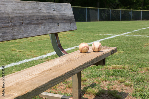 Baseball on a bench in a little league field