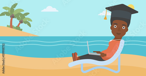 Graduate lying on chaise lounge with laptop.
