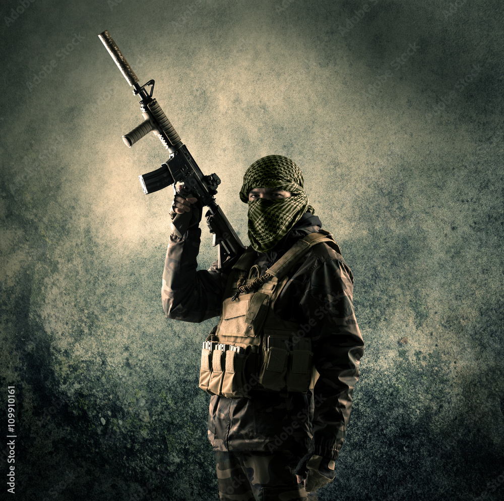 Φωτογραφία Portrait of a heavily armed masked soldier with grungy backgroun