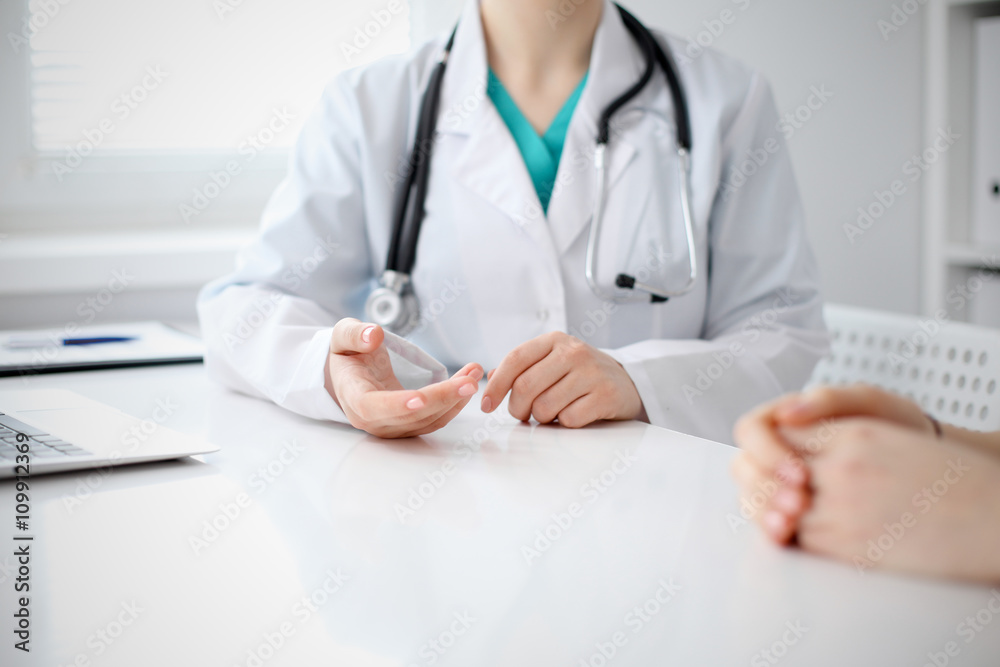 Doctor and patient are discussing something, just hands at the table Doctor and patient are discussing something, just hands at the table