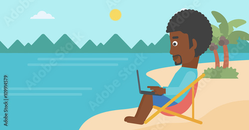 Businessman sitting in chaise lounge with laptop.