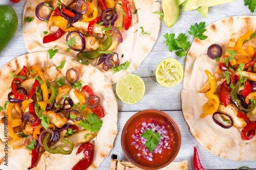 Foto Homemade chicken Fajitas with vegetables, lime and salsa sauce,