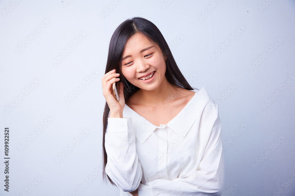 Chinese woman in white talking on a cell phone Chinese woman in white talking on a cell phone