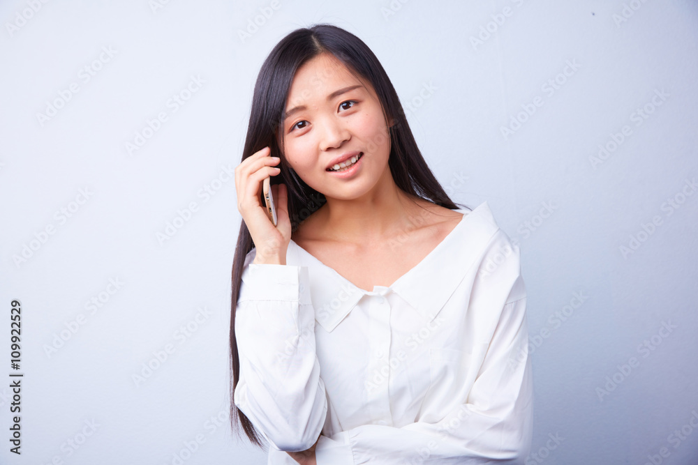 Chinese woman in white talking on a cell phone Chinese woman in white talking on a cell phone