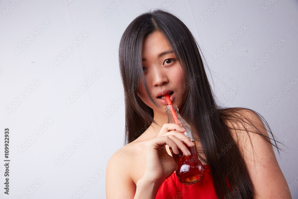 Naklejka premium Chinese woman drinking carbonated drink through a straw