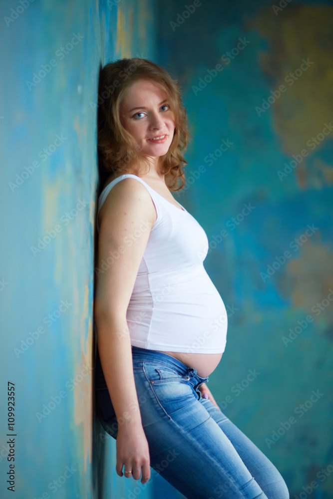 Pregnant woman in jeans in studio Pregnant woman in jeans in studio
