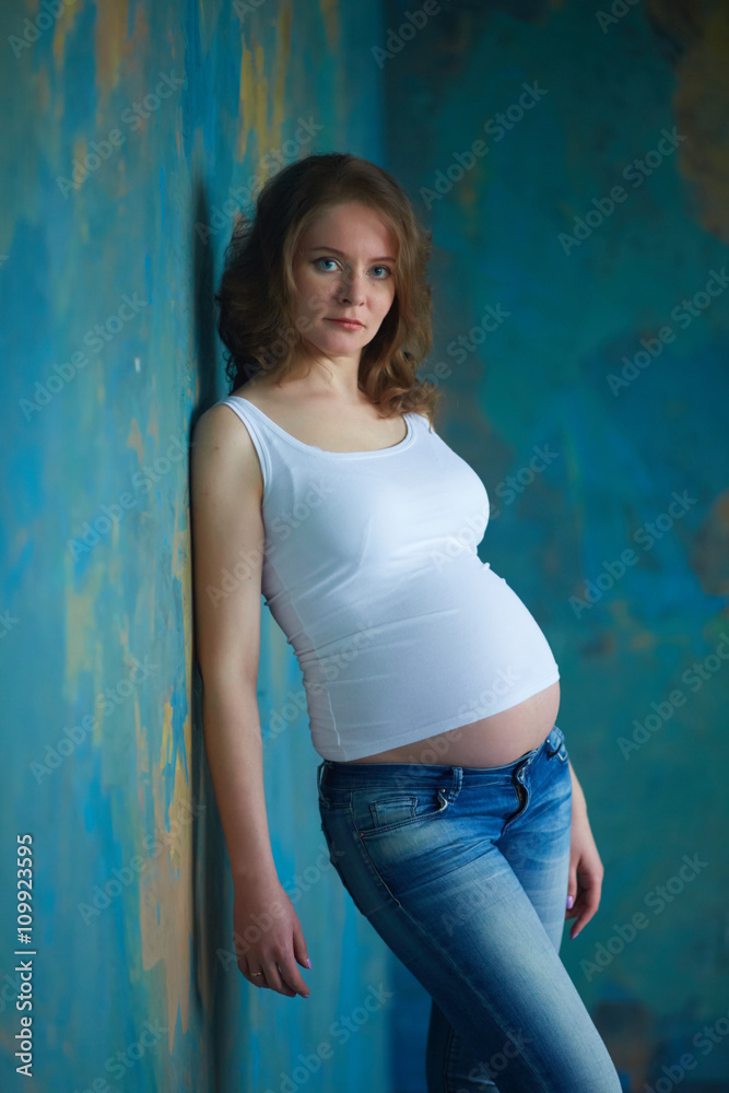 Pregnant woman in jeans in studio Pregnant woman in jeans in studio