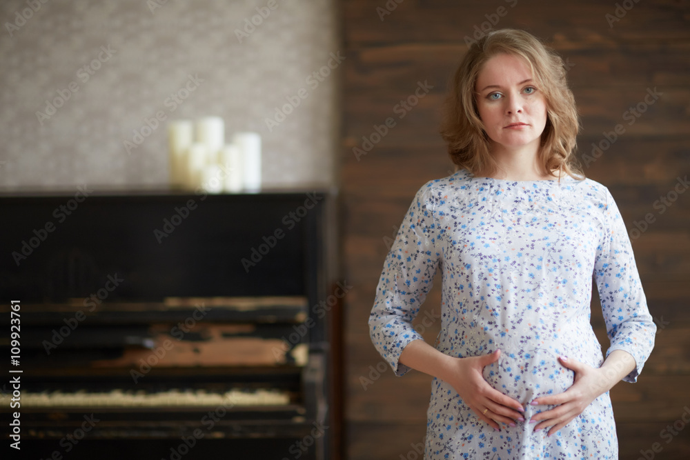 pregnant woman in a white dress near piano pregnant woman in a white dress near piano