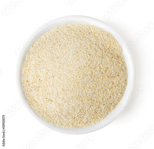Bowl of semolina on white background, top view photo