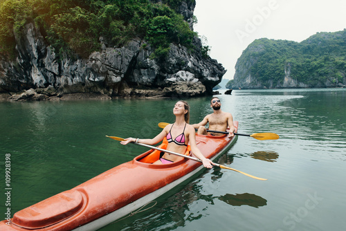 Couple relax on kayak in Halong Bay. Adventure on water