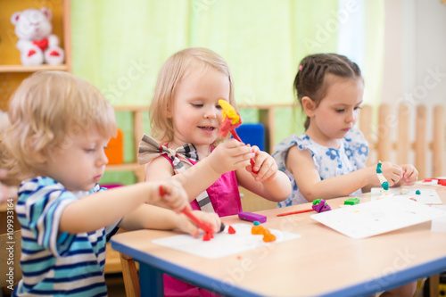 kids group making arts and crafts in kindergarten with interest