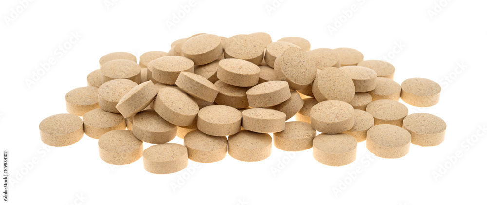 Group of brewer’s yeast nutritional supplement tablets on a white background side view Group of brewer’s yeast nutritional supplement tablets on a white background side view