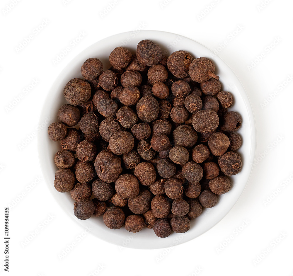Bowl of allspice grains isolated on white, top view Bowl of allspice grains isolated on white, top view