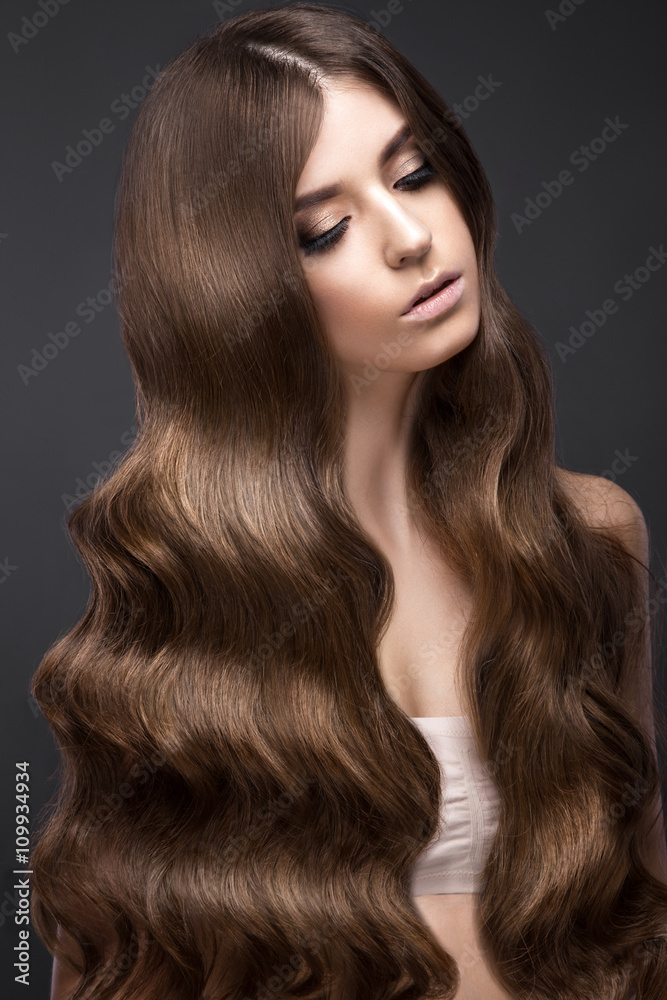 Beautiful brunette girl with a perfectly curls hair and classic make-up. Beauty face. Beautiful brunette girl with a perfectly curls hair and classic make-up. Beauty face.