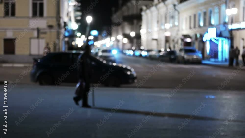 The old man with walking stick shuffled feebly along night street with fancy lights, vintage color, colorized shot. Defocused The old man with walking stick shuffled feebly along night street with fancy lights, vintage color, colorized shot. Defocused