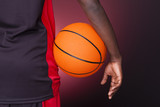 Back view of afro american basketball player holding a ball on d