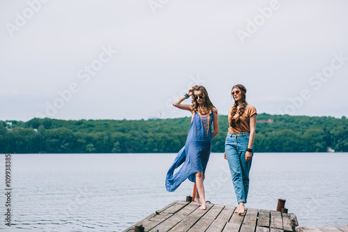 two beautiful girl friends on the dock