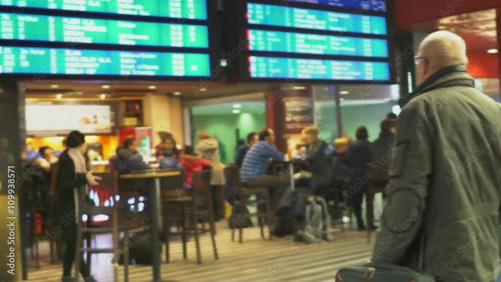 Cafeteria in the waiting room, old man with eyeglasses looking at train schedule Cafeteria in the waiting room, old man with eyeglasses looking at train schedule
