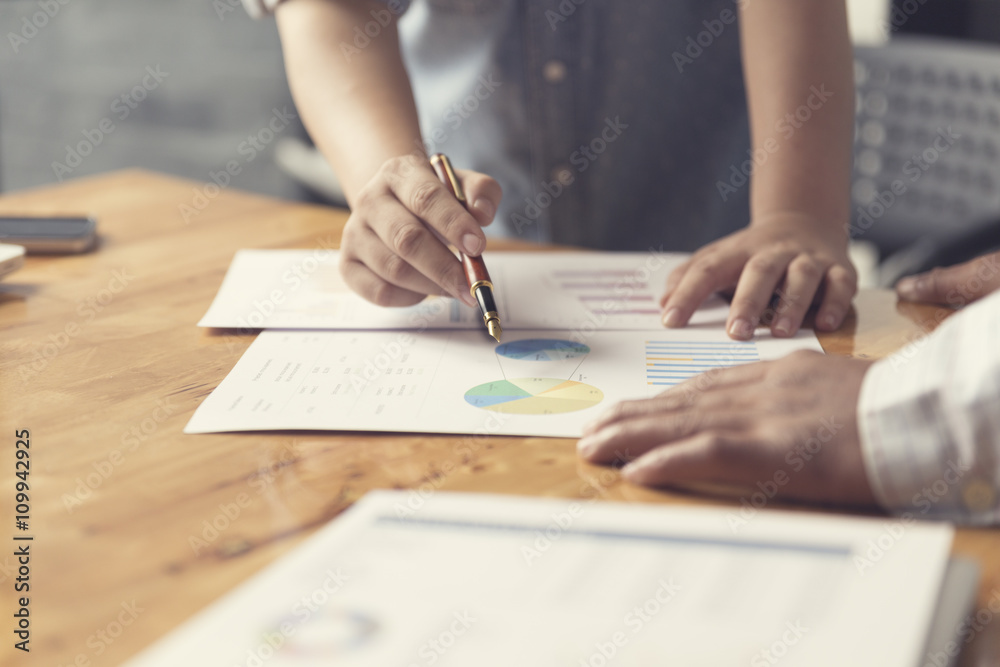 woman's hand holding pen working with document, selective focus