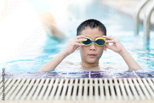 Happy asian boy playing in the pool