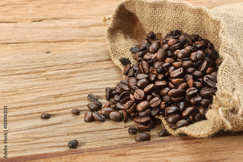 Coffee beans with burlap sack on wood background Coffee beans with burlap sack on wood background