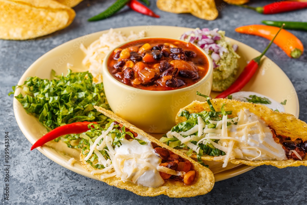 Tacos with chili con carne, salad, cheese and sour cream. Tacos with chili con carne, salad, cheese and sour cream.