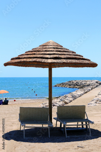 Beach with parasols made with bamboo and straw in the resort