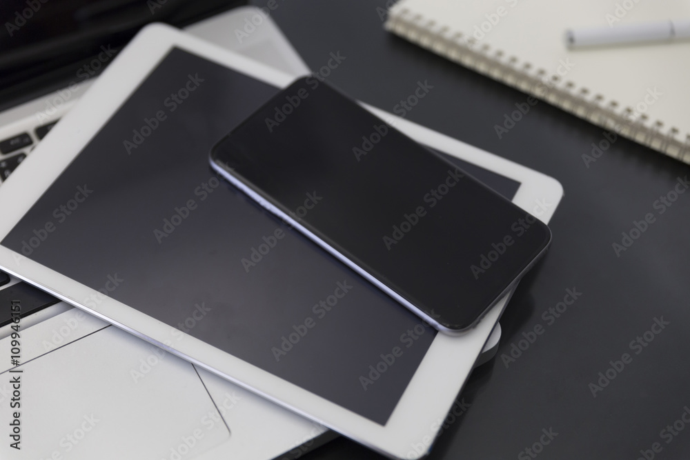 laptop computer, digital tablet and mobile phone on black table laptop computer, digital tablet and mobile phone on black table