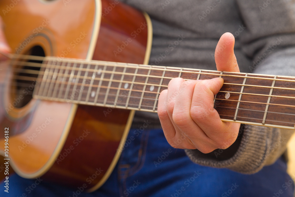 Fototapeta premium Hände eines jungen Mannes der Gitarre spielt