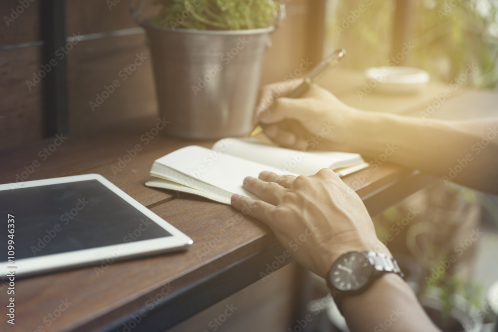 Fototapeta premium man writing on notebook with digital tablet