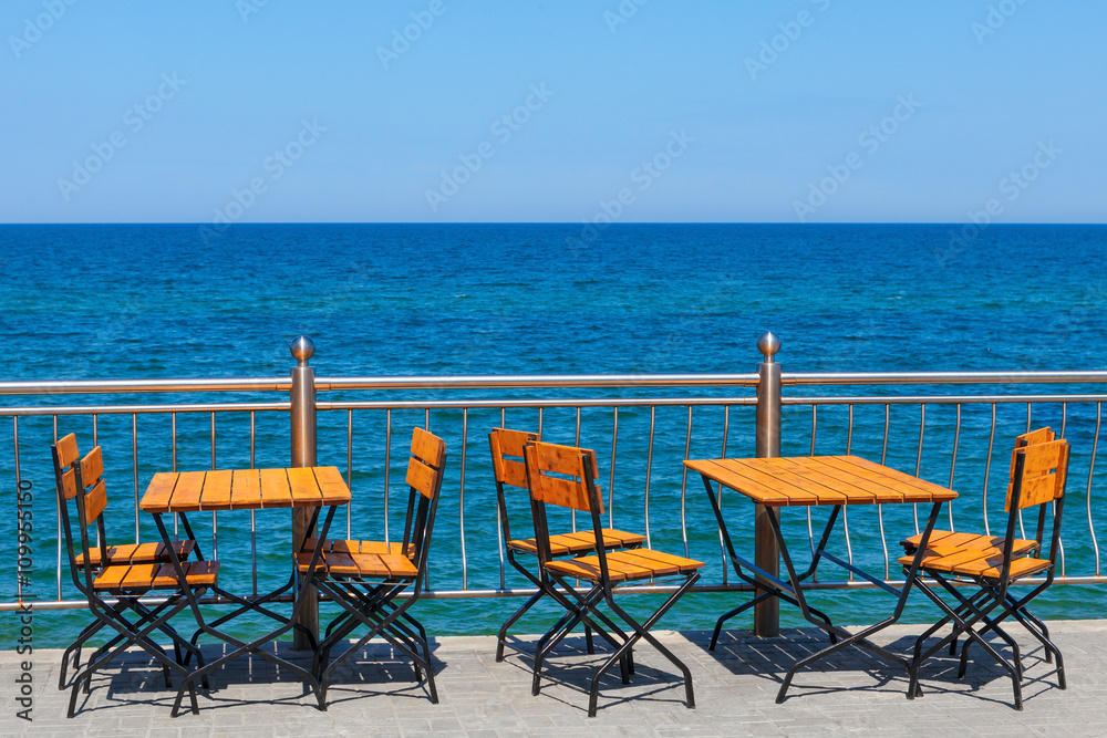 tables and chairs on the background of the sea.