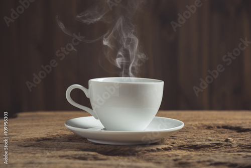 white coffee cup with smoke on wooden table